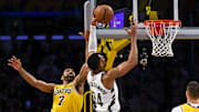 Mar 20, 2025; Los Angeles, California, USA; Los Angeles Lakers guard Gabe Vincent (7) attempts to block Milwaukee Bucks forward Giannis Antetokounmpo (34) during the second half at Crypto.com Arena. Mandatory Credit: Jonathan Hui-Imagn Images