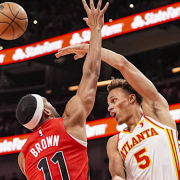 Jan 25, 2025; Atlanta, Georgia, USA; Atlanta Hawks guard Dyson Daniels (5) passes over Toronto Raptors forward Bruce Brown (11) during the first half at State Farm Arena. Mandatory Credit: Dale Zanine-Imagn Images