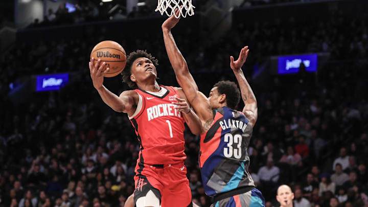 Jan 27, 2024; Brooklyn, New York, USA;  Houston Rockets forward Amen Thompson (1) looks to drive past Brooklyn Nets center Nic Claxton (33) in the fourth quarter at Barclays Center. Mandatory Credit: Wendell Cruz-Imagn Images