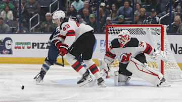 New Jersey Devils defenseman Luke Hughes (43) picks up a loose puck from goalie Jake Allen (34). Mandatory Credit: Russell LaBounty-Imagn Images