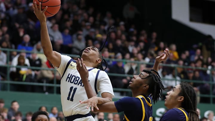 Hoban guard Kenny Scott, left, looks for a layup over a pair of Garfield Heights players during the first half of a Division III regional championship basketball game on Friday, March 7, 2025, in Medina, Ohio. Hoban guard Kenny Scott, left, looks for a layup over a pair of Garfield Heights players during the first half of a Division III regional championship basketball game on Friday, March 7, 2025, in Medina, Ohio.