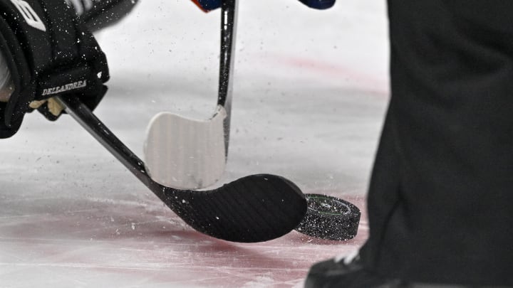 Feb 26, 2024; Dallas, Texas, USA; A view of the face-off circle and an NHL puck and the Dallas Stars logo and hockey sticks during a face-off in the third period of the game between the Dallas Stars and the New York Islanders at the American Airlines Center. Mandatory Credit: Jerome Miron-USA TODAY Sports