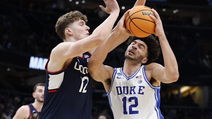 Duke Blue Devils forward Cameron Boozer (12) goes to the basket against UConn Huskies center Eric Reibe (12)