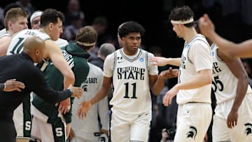 Michigan State Spartans guard Jase Richardson (11) is swarmed by teammates after a shot during the second half of an NCAA Tournament Second Round game against the New Mexico Lobos at Rocket Arena on Sunday, March 23, 2025, in Cleveland, Ohio.