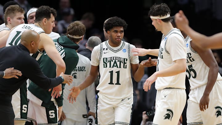 Michigan State Spartans guard Jase Richardson (11) is swarmed by teammates after a shot during the second half of an NCAA Tournament Second Round game against the New Mexico Lobos at Rocket Arena on Sunday, March 23, 2025, in Cleveland, Ohio.