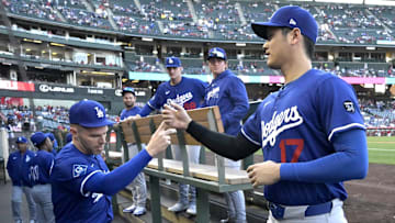 Mar 24, 2025; Anaheim, California, USA;  Los Angeles Dodgers designated hitter Shohei Ohtani (17) is greeted by first baseman Freddie Freeman (5) in the dugout for the game against the Los Angeles Angels at Angel Stadium. 