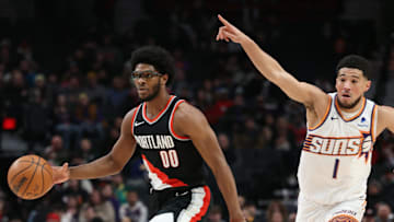 Portland Trail Blazers guard Scoot Henderson dribbles the ball as Phoenix Suns guard Devin Booker directs traffic.