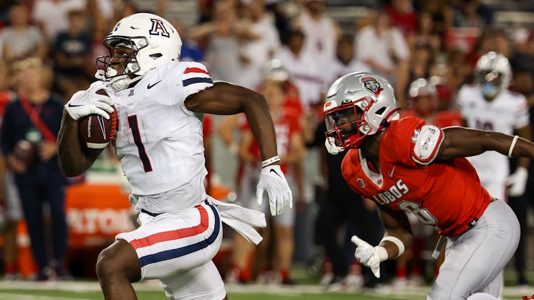 Aug 31, 2024; Tucson, Arizona, USA; Arizona Wildcats running back Jacory Croskey-Merritt (1) runs the ball for a touchdown while New Mexico Lobos safety Christian Ellis (8) chases him during fourth quarter at Arizona Stadium