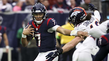 Dec 3, 2023; Houston, Texas, USA; Houston Texans quarterback C.J. Stroud (7) attempts to escape the grasp of Denver Broncos linebacker Alex Singleton (49) during the fourth quarter at NRG Stadium. Mandatory Credit: Troy Taormina-Imagn Images