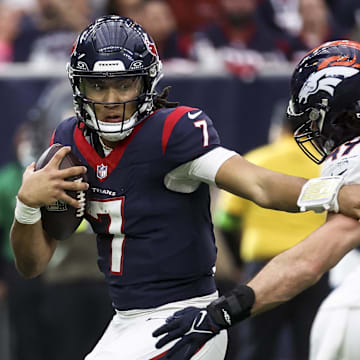 Dec 3, 2023; Houston, Texas, USA; Houston Texans quarterback C.J. Stroud (7) attempts to escape the grasp of Denver Broncos linebacker Alex Singleton (49) during the fourth quarter at NRG Stadium. Mandatory Credit: Troy Taormina-Imagn Images