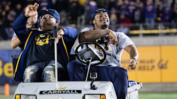 Nov 5, 2016; Berkeley, CA, USA; Retired NFL running back Marshawn Lynch (R) drives the injury cart with rapper E-40 (L), before the game against the Washington Huskies for the 10 year anniversary of driving the cart after a win as a California Golden Bears player at Memorial Stadium. Mandatory Credit: Kelley L Cox-Imagn Images