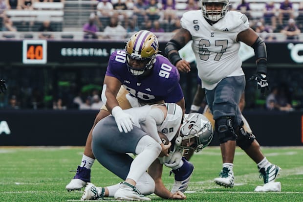 Elinneus Davis (90) brought down Eastern Michigan QB Cole Snyder for a sack. 