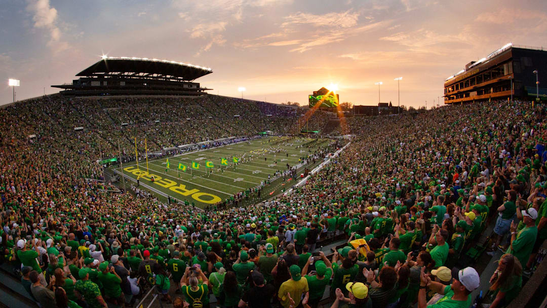 The sun sets over Autzen Stadium as Oregon players and cheerleaders take the field for the game against Boise State in Eugene Sept. 7, 2024.