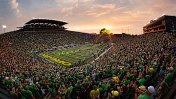 The sun sets over Autzen Stadium as Oregon players and cheerleaders take the field for the game against Boise State in Eugene Sept. 7, 2024.