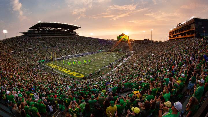 The sun sets over Autzen Stadium as Oregon players and cheerleaders take the field for the game against Boise State in Eugene Sept. 7, 2024.