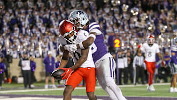 Nov 23, 2024; Manhattan, Kansas, USA; Cincinnati Bearcats wide receiver Tony Johnson (0) scores a touchdown against Kansas State Wildcats safety VJ Payne (19) during the third quarter at Bill Snyder Family Football Stadium. Mandatory Credit: Scott Sewell-Imagn Images