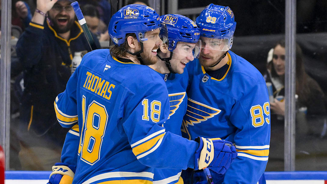 Apr 5, 2025; St. Louis, Missouri, USA;  St. Louis Blues left wing Pavel Buchnevich (89) celebrates with right wing Jimmy Snuggerud (21) and center Robert Thomas (18) after scoring against the Colorado Avalanche during the second period at Enterprise Center. Mandatory Credit: Jeff Curry-Imagn Images