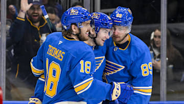 Apr 5, 2025; St. Louis, Missouri, USA;  St. Louis Blues left wing Pavel Buchnevich (89) celebrates with right wing Jimmy Snuggerud (21) and center Robert Thomas (18) after scoring against the Colorado Avalanche during the second period at Enterprise Center. Mandatory Credit: Jeff Curry-Imagn Images