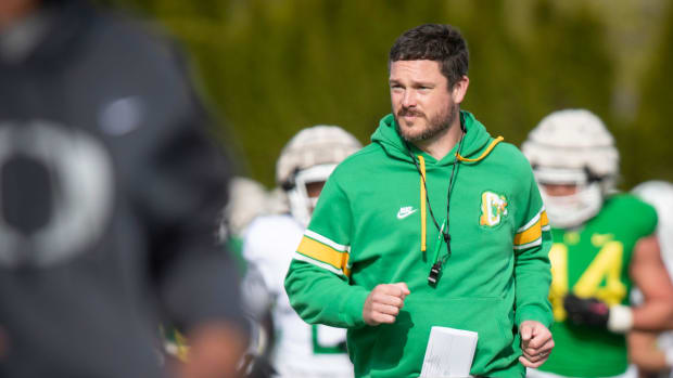 Oregon head coach Dan Lanning runs during practice with the Ducks