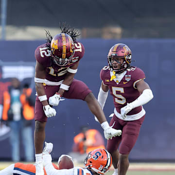 Dec 29, 2022; Bronx, NY, USA; Minnesota Golden Gophers defensive back Darius Green (12) reacts after stopping Syracuse Orange wide receiver Trebor Pena (2) on fourth down during the second quarter of the 2022 Pinstripe Bowl at Yankee Stadium. Mandatory Credit: Brad Penner-Imagn Images