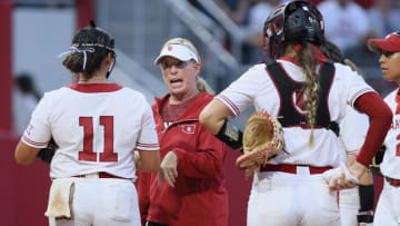 Patty Gasso talks with Oklahoma starting pitcher Kierston Deal (11) during a Bedlam softball game between the University of Oklahoma Sooners (OU) and the Oklahoma State Cowgirls (OSU) at Love's Field in Norman, Okla.,  