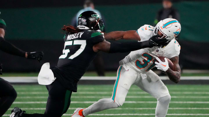 Nov 24, 2023; East Rutherford, NJ; New York Jets linebacker C.J. Mosley (57) tries to stop Miami Dolphins running back Raheem Mostert (31) in the second half at MetLife Stadium