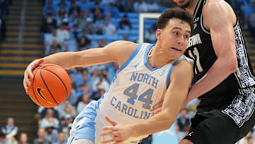 Dec 7, 2025; Chapel Hill, North Carolina, USA;  North Carolina Tar Heels guard Luka Bogavac (44) with the ball as Georgetown Hoyas center Julius Halaifonua (11) defends in the second half at Dean E. Smith Center. Mandatory Credit: Bob Donnan-Imagn Images
