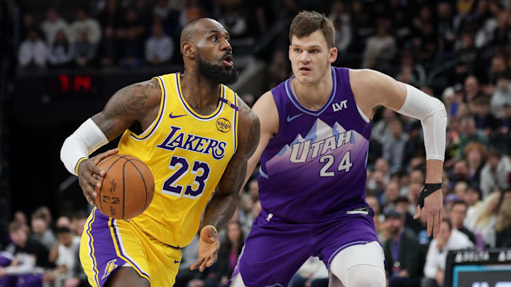 Feb 12, 2025; Salt Lake City, Utah, USA;  Los Angeles Lakers forward LeBron James (23) dribbles past Utah Jazz center Walker Kessler (24) during the first quarter at Delta Center. Mandatory Credit: Chris Nicoll-Imagn Images