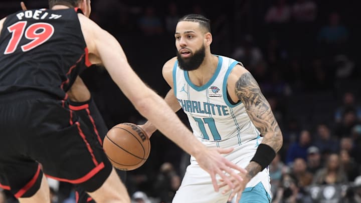 Feb 7, 2024; Charlotte, North Carolina, USA; Charlotte Hornets forward Cody Martin (11) looks to drive in against Toronto Raptors center Jakob Poeltl (19) during the first half at the Spectrum Center. Mandatory Credit: Sam Sharpe-USA TODAY Sports