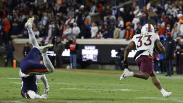 Nov 25, 2023; Charlottesville, Virginia, USA; Virginia Tech Hokies running back Bhayshul Tuten (33) carries the ball past Virginia Cavaliers cornerback Sam Westfall (13) during the third quarter at Scott Stadium. Mandatory Credit: Geoff Burke-USA TODAY Sports