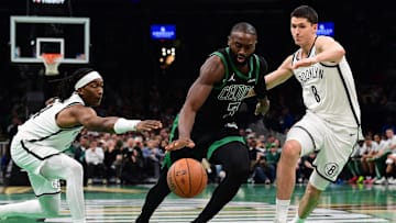 Nov 21, 2025; Boston, Massachusetts, USA; Boston Celtics guard Jaylen Brown (7) controls the ball between Brooklyn Nets guard Terance Mann (14) and guard Egor Demin (8) during the second half at TD Garden. Mandatory Credit: Bob DeChiara-Imagn Images