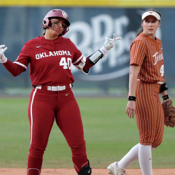 Oklahoma's Alynah Torres (40) gestures next to Texas' Leighann Goode (43) after reaching second base during the Big 12 Tournament championship game on May 11, 2024.
