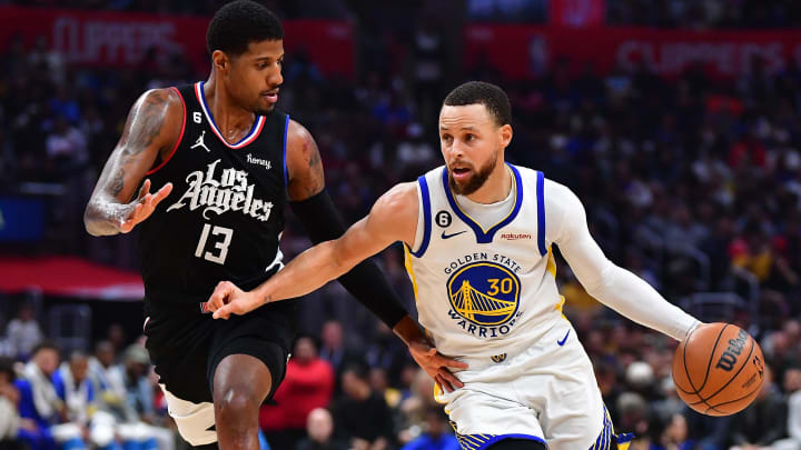 Warriors guard Stephen Curry moves the ball while Clippers forward Paul George defends during a game in March 2023.