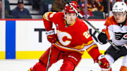 Oct 12, 2024; Calgary, Alberta, CAN; Calgary Flames left wing Samuel Honzek (29) and Philadelphia Flyers right wing Owen Tippett (74) battles for the puck during the third period at Scotiabank Saddledome. Mandatory Credit: Sergei Belski-Imagn Images