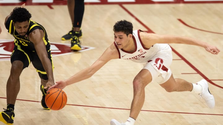 Feb 22, 2024; Stanford, California, USA; Oregon Ducks guard Kario Oquendo (left) and Stanford Cardinal forward Brandon Angel (23) dive for a loose ball during the second half at Maples Pavilion.