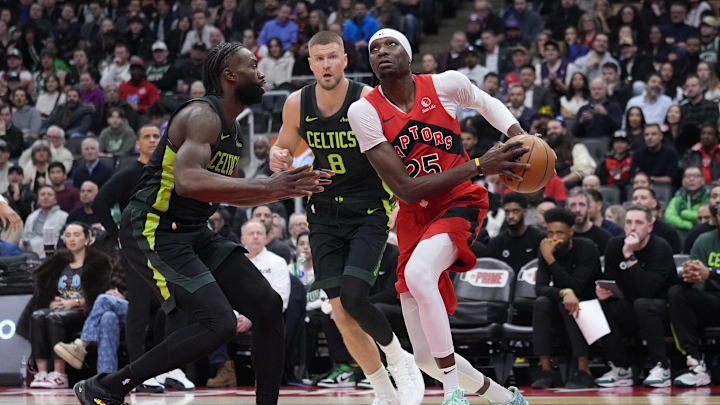 Jan 15, 2025; Toronto, Ontario, CAN; Toronto Raptors forward Chris Boucher (25) drives against Boston Celtics forward Jaylen Brown (7) and center Kristaps Porzingis (8) during the second half at Scotiabank Arena. Mandatory Credit: John E. Sokolowski-Imagn Images
