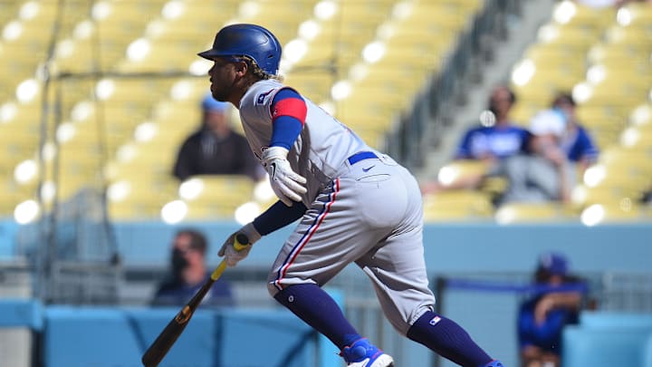 Jun 13, 2021; Los Angeles, California, USA; Texas Rangers left fielder Willie Calhoun (5) hits an RBI single against the Los Angeles Dodgers during the ninth inning at Dodger Stadium. Mandatory Credit: Gary A. Vasquez-Imagn Images