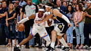 Oklahoma City Thunder guard Shai Gilgeous-Alexander controls the ball as Denver Nuggets forward Aaron Gordon guards.