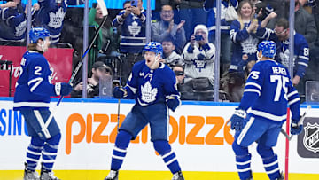 Dec 31, 2024; Toronto, Ontario, CAN; Toronto Maple Leafs center Steven Lorentz (18) scores a goal and celebrates with defenseman Simon Benoit (2) against the New York Islanders during the second period at the Scotiabank Arena. Mandatory Credit: Nick Turchiaro-Imagn Images