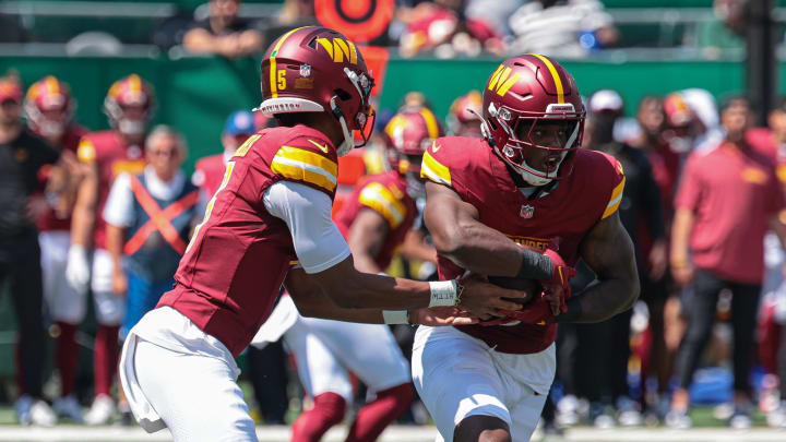 Aug 10, 2024; East Rutherford, New Jersey, USA; Washington Commanders quarterback Jayden Daniels (5) hands off to running back Brian Robinson Jr. (8) during the first quarter against the New York Jets at MetLife Stadium. Mandatory Credit: Vincent Carchietta-USA TODAY Sports