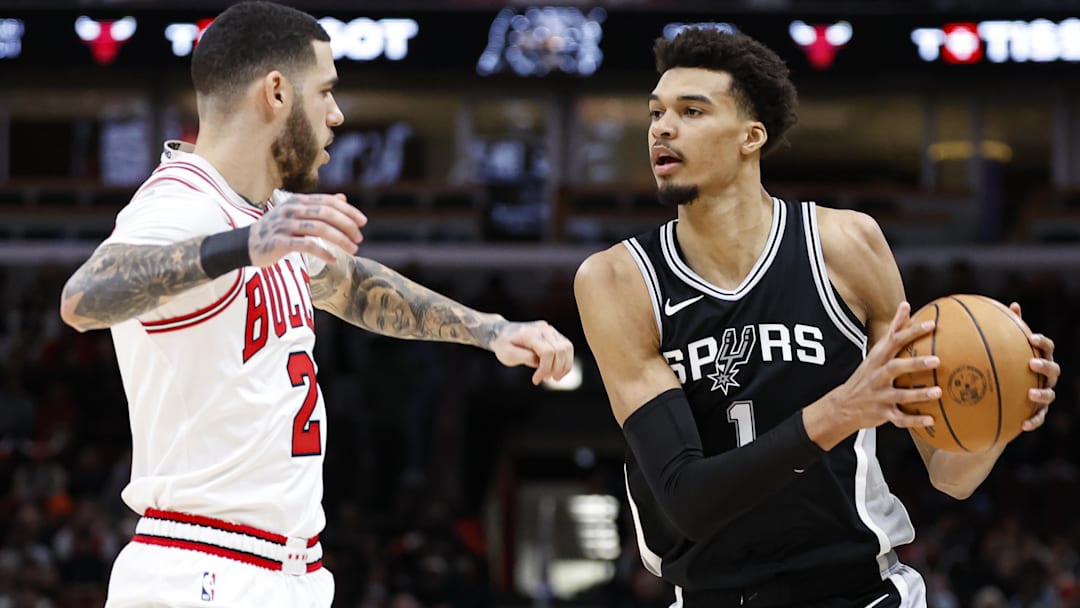 Jan 6, 2025; Chicago, Illinois, USA; San Antonio Spurs center Victor Wembanyama (1) looks to pass the ball against Chicago Bulls guard Lonzo Ball (2) during the first half at United Center. Mandatory Credit: Kamil Krzaczynski-Imagn Images