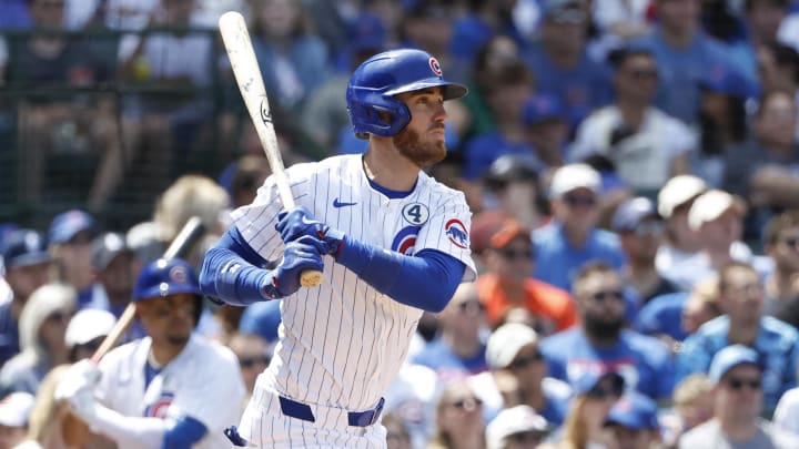 Jun 2, 2024; Chicago, Illinois, USA; Chicago Cubs outfielder Cody Bellinger (24) hits an RBI single against the Cincinnati Reds during the fifth inning at Wrigley Field.