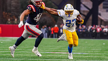 Dec 28, 2024; Foxborough, Massachusetts, USA; Los Angeles Chargers running back J.K. Dobbins (27) runs the ball against New England Patriots linebacker Jahlani Tavai (48) in the second half at Gillette Stadium. Mandatory Credit: David Butler II-Imagn Images