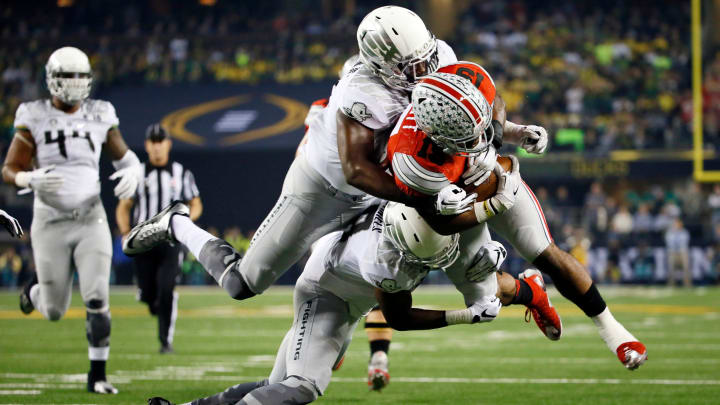 Ohio State Buckeyes running back Ezekiel Elliott (15) lunges toward the goal line, but is tackled just short by Oregon Ducks defensive back Reggie Daniels (8) and linebacker Tony Washington (91) during the first quarter of the College Football Playoff National Championship at AT&T Stadium in Arlington, Texas on Jan. 12, 2015.