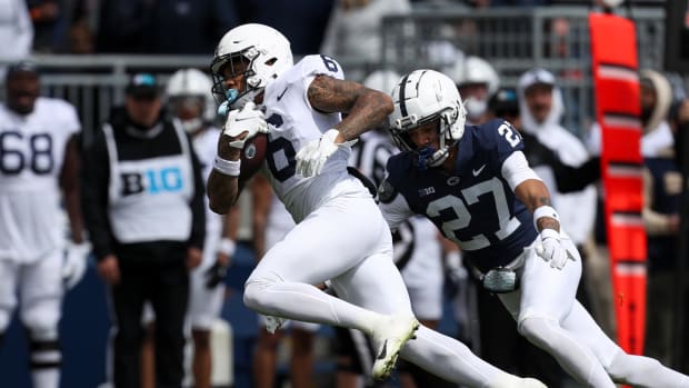 Penn State's Harrison Wallace III runs with the football while a player tries to catch him.