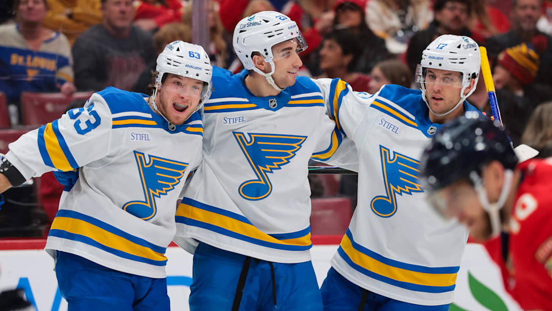 Dec 20, 2025; Sunrise, Florida, USA; St. Louis Blues left wing Jake Neighbours (63) celebrates with defenseman Logan Mailloux (23) and defenseman Cam Fowler (17) after scoring against the Florida Panthers during the first period at Amerant Bank Arena. Mandatory Credit: Sam Navarro-Imagn Images