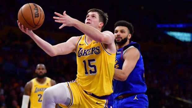 Apr 25, 2024; Los Angeles, California, USA; Los Angeles Lakers guard Austin Reaves (15) shoots ahead of Denver Nuggets guard Jamal Murray (27) during the second half in game three of the first round for the 2024 NBA playoffs at Crypto.com Arena. Mandatory Credit: Gary A. Vasquez-USA TODAY Sports