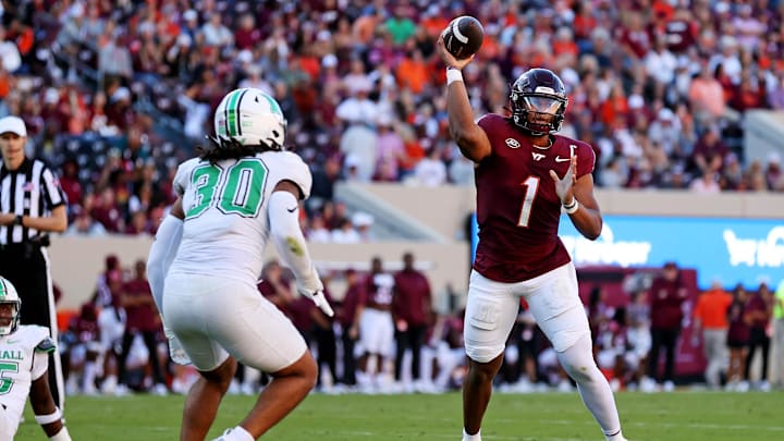 Sep 7, 2024; Blacksburg, Virginia, USA; Virginia Tech Hokies quarterback Kyron Drones (1) throws a pass against Marshall Thundering Herd linebacker Jaden Yates (30) during the second quarter at Lane Stadium. Mandatory Credit: Peter Casey-Imagn Images