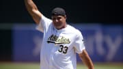 Former Oakland Athletics star Jose Canseco pumps his fist after throwing out the ceremonial first pitch before a game against the Los Angeles Angels at Oakland-Alameda County Coliseum on July 20.