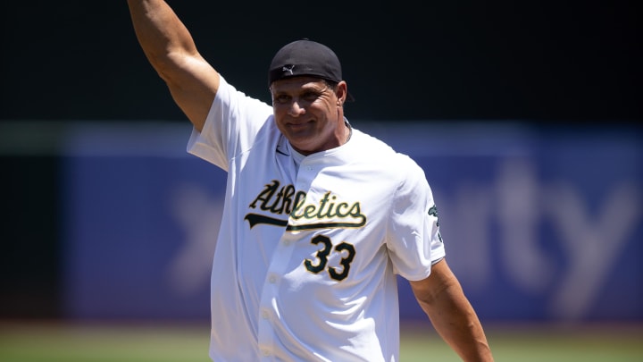 Former Oakland Athletics star Jose Canseco pumps his fist after throwing out the ceremonial first pitch before a game against the Los Angeles Angels at Oakland-Alameda County Coliseum on July 20.